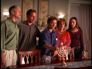 Louis lights the first candle of the menorah because that's what Jewish people do, you see.